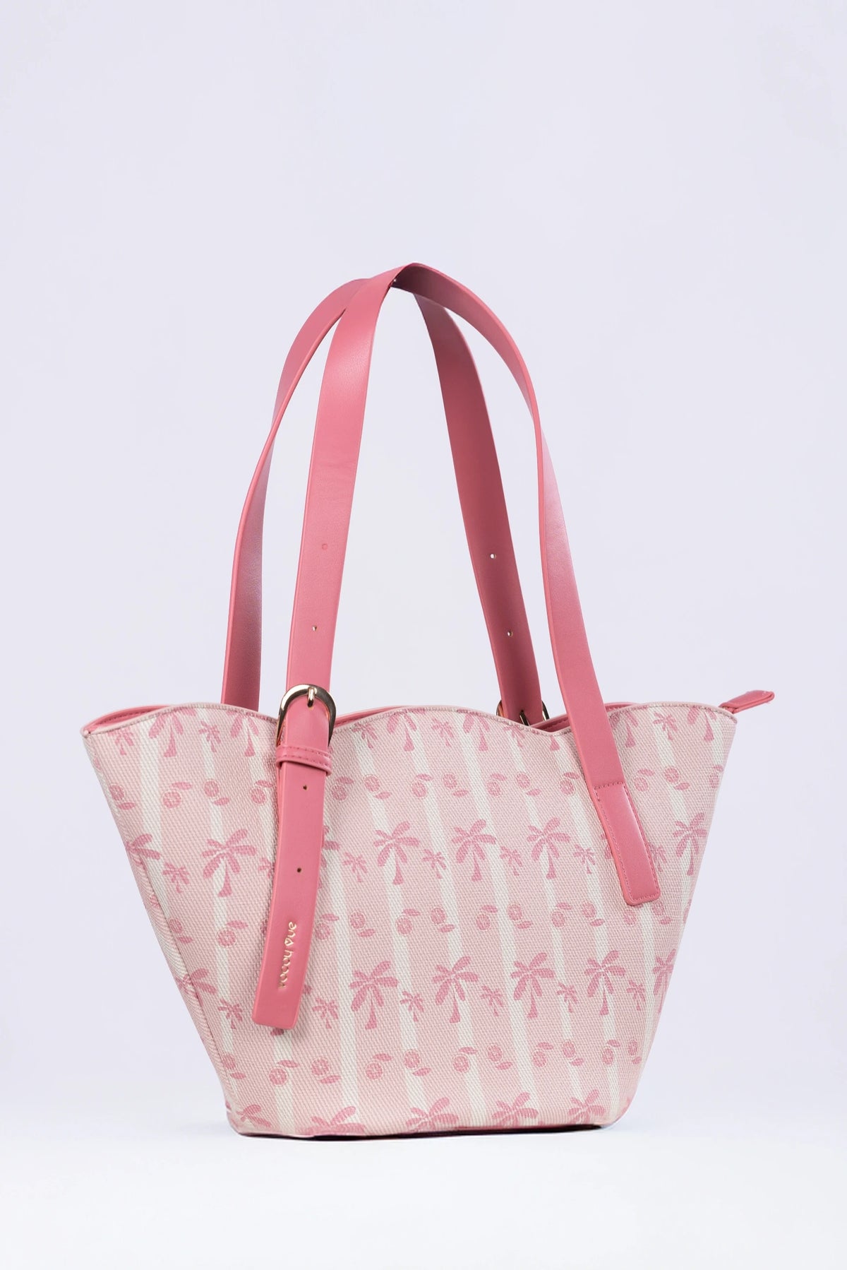 Pink floral-patterned handbag with pink straps on a light purple background