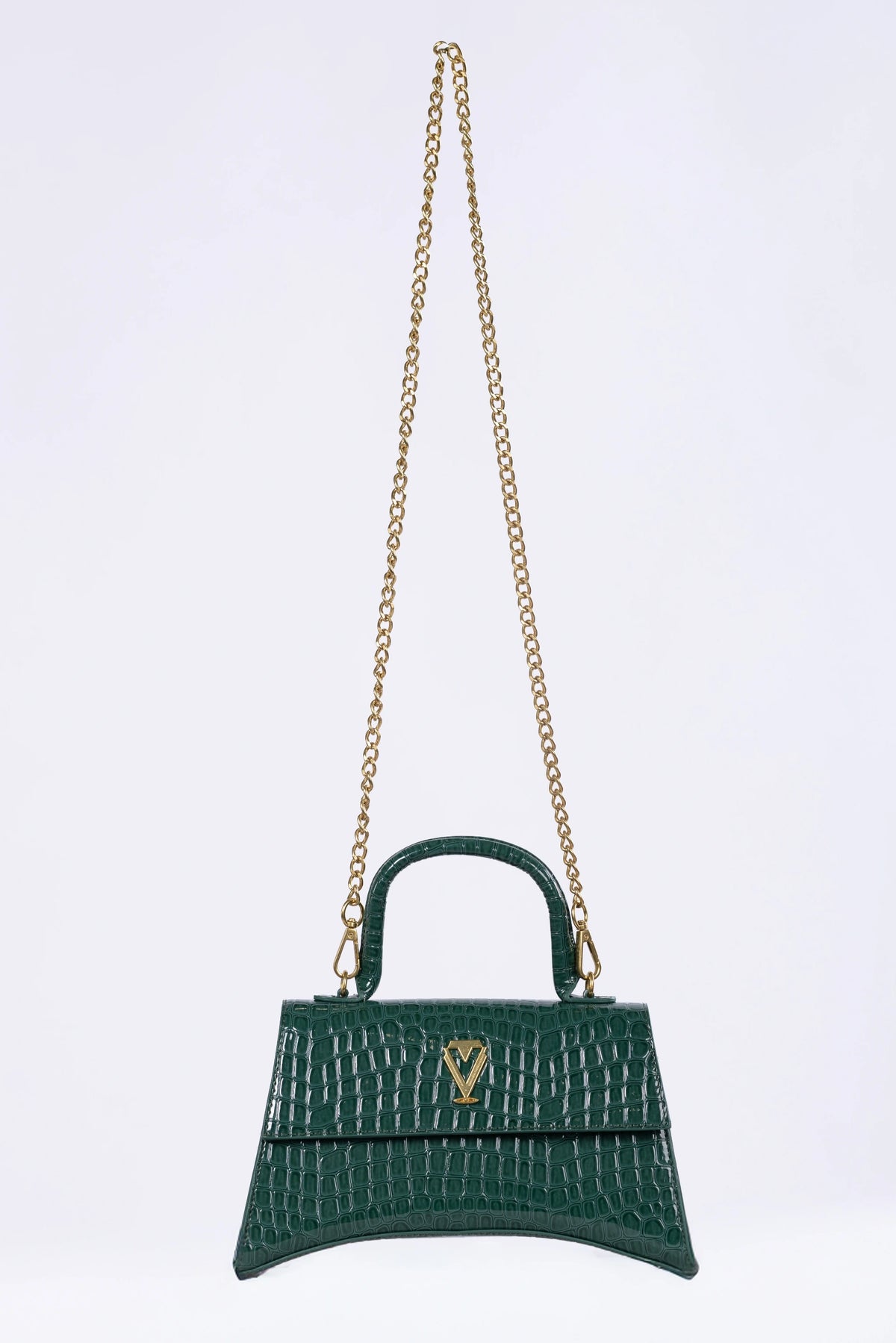 Green handbag with gold chain on a light purple background